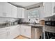 Modern kitchen featuring granite counters, white cabinets, and stainless steel dishwasher at 406 Country Park Se Dr, Smyrna, GA 30080