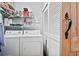 Efficient laundry room featuring washer, dryer, storage shelves, and nearby closet at 406 Country Park Se Dr, Smyrna, GA 30080