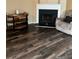 Cozy living room features dark wood flooring, a fireplace, and comfortable armchair at 10600 Pine Forest Ln, Jonesboro, GA 30238