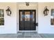 Elegant front door with decorative glass, flanked by lantern-style sconces, for a welcoming entrance at 18 Polo Ne Dr, Atlanta, GA 30309