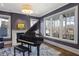 Sophisticated living room featuring a grand piano, fireplace, and large windows with treetop views at 18 Polo Ne Dr, Atlanta, GA 30309