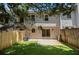Backyard featuring artificial turf, wood fence, stone patio, and view of the home's rear elevation at 657 Stratford Green Way, Avondale Estates, GA 30002