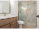 Modern bathroom features a glass shower with decorative tile, wooden vanity, and stylish fixtures at 657 Stratford Green Way, Avondale Estates, GA 30002