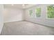 Bright bedroom with plush carpet, modern ceiling fan, and plenty of natural light from three windows at 657 Stratford Green Way, Avondale Estates, GA 30002