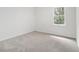 Bright bedroom offers neutral carpet, natural light, and view of exterior foliage at 657 Stratford Green Way, Avondale Estates, GA 30002