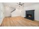 Spacious living room with wood floors, a cozy fireplace, and a modern ceiling fan at 657 Stratford Green Way, Avondale Estates, GA 30002