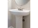 White pedestal sink beneath round mirror, complemented by neutral wall color at 806 Chelsea Wood Ct, Stockbridge, GA 30281