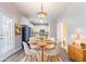 Charming dining area with a chandelier, leading to a modern kitchen, perfect for Gathering meals and entertaining guests at 806 Chelsea Wood Ct, Stockbridge, GA 30281