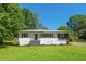 Inviting single-story home with landscaped front yard, white painted brick and wood accent shutters at 941 Shirley Se St, Smyrna, GA 30082