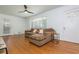 Inviting living room featuring hardwood floors, ceiling fan, a comfortable sofa, and plenty of natural light at 941 Shirley Se St, Smyrna, GA 30082
