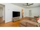 Bright living room with hardwood floors, ceiling fan, large windows, comfortable sofa and TV at 941 Shirley Se St, Smyrna, GA 30082