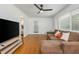 Bright living room with hardwood floors, ceiling fan, large windows, and comfortable sofa at 941 Shirley Se St, Smyrna, GA 30082