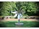 Ground-level stainless steel flower artwork on a green lawn in a shady community park area at 12 Pine St, Roswell, GA 30075