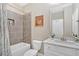 Modern bathroom with tub and tiled shower, neutral walls, white cabinets, and a vanity with a stone countertop at 12 Pine St, Roswell, GA 30075