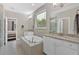 Bright bathroom featuring double sinks, soaking tub, and a glass shower at 12 Pine St, Roswell, GA 30075