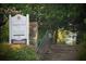 Scenic entrance to Barrington Hall featuring a stately sign, stone steps, and lush greenery at 12 Pine St, Roswell, GA 30075
