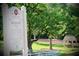 Picturesque view of Bulloch Hall with lush greenery, a traditional well, and a charming gazebo at 12 Pine St, Roswell, GA 30075