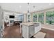 Open kitchen with an island sink, hardwood floors, and backyard views at 12 Pine St, Roswell, GA 30075