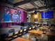 Spacious restaurant interior featuring a stage, large screens, bar area, and ample seating for patrons at 12 Pine St, Roswell, GA 30075