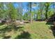 Large, grassy backyard with mature trees and a sloped landscape at 230 Oakridge Se Dr, Cartersville, GA 30121