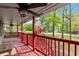 Inviting red porch with an American flag, ceiling fans, and wood furniture at 230 Oakridge Se Dr, Cartersville, GA 30121