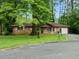 Traditional brick home with well-maintained lawn, surrounded by lush trees at 3047 Hudson Ct, Decatur, GA 30033
