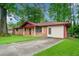 Quaint single-story brick home featuring a well-kept lawn and a paved driveway at 3047 Hudson Ct, Decatur, GA 30033