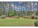 Lush backyard featuring green lawn, mature trees, and privacy landscaping for a serene outdoor setting at 3140 Thoreau Ct, Loganville, GA 30052