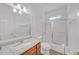 Clean bathroom with wood vanity, marble countertops, and tiled shower with glass door enclosure at 3140 Thoreau Ct, Loganville, GA 30052