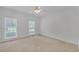 Bright bedroom with neutral carpet, white walls, ceiling fan, and dual windows for natural light at 3140 Thoreau Ct, Loganville, GA 30052