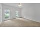 Spacious bedroom featuring soft carpet, white trim, two windows, and ceiling fan with decorative lighting at 3140 Thoreau Ct, Loganville, GA 30052