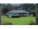 Exterior view of a house surrounded by mature trees and a well-manicured lawn at 3140 Thoreau Ct, Loganville, GA 30052