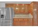 A kitchen featuring wooden cabinetry, granite countertops and a stainless steel refrigerator at 3140 Thoreau Ct, Loganville, GA 30052