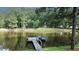 Beautiful lake view featuring a wooden dock and a canoe for enjoying the serene water at 3140 Thoreau Ct, Loganville, GA 30052