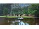 Picturesque lakefront home featuring private dock with lush landscaping and mature trees at 3140 Thoreau Ct, Loganville, GA 30052