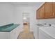 Efficient laundry room with modern washer/dryer, ample storage cabinets, and tiled flooring at 3140 Thoreau Ct, Loganville, GA 30052