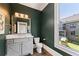 Powder room with dark green walls, a gray vanity, and a window overlooking the backyard at 3834 Chamblee Dunwoody Rd, Atlanta, GA 30341