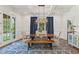 The dining room includes a modern light fixture, a long table, and a blue patterned rug at 3834 Chamblee Dunwoody Rd, Atlanta, GA 30341