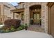 A welcoming front entrance with stone accents, landscaping, and double wooden doors at 3834 Chamblee Dunwoody Rd, Atlanta, GA 30341