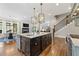 Spacious kitchen with center island, stainless appliances, and modern lighting flowing into eating area at 3834 Chamblee Dunwoody Rd, Atlanta, GA 30341