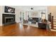 A well-lit living room has a fireplace, a ceiling fan, hardwood floors, and ample seating at 3834 Chamblee Dunwoody Rd, Atlanta, GA 30341