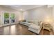 Spacious living room with hardwood floors, a comfortable sofa, and glass doors leading to an outdoor space at 3834 Chamblee Dunwoody Rd, Atlanta, GA 30341