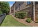 Brick home featuring a well-manicured side yard with lush greenery and a partial fence at 3834 Chamblee Dunwoody Rd, Atlanta, GA 30341