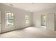 Sunlit bedroom with hardwood floors features light walls, complemented by windows that offer picturesque outdoor views at 1115 Ralph Ne Rd, Atlanta, GA 30324