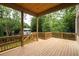 A spacious wooden deck overlooks a lush backyard with mature trees and a glimpse of neighboring houses at 1115 Ralph Ne Rd, Atlanta, GA 30324