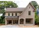 Stunning new construction featuring a gray brick exterior, covered porch, and an attached two-car garage at 1115 Ralph Ne Rd, Atlanta, GA 30324