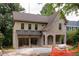 An attractive two-story home displays a brick and siding exterior with a two-car garage below a metal awning at 1115 Ralph Ne Rd, Atlanta, GA 30324