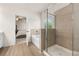 Bright bathroom featuring a separate shower and tub, with wood-look floors and an open doorway to the bedroom at 228 Whitneys Way, Dallas, GA 30157