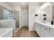 Bathroom featuring a double vanity, shower and tub, with white cabinets and tile at 228 Whitneys Way, Dallas, GA 30157