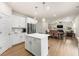 Open concept kitchen features an island, stainless steel appliances, and seamlessly connects to the dining and living areas at 228 Whitneys Way, Dallas, GA 30157